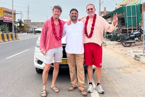 Tourists welcomed beside a white Innova Crysta
