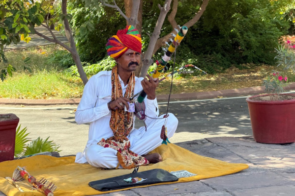 Traveler practicing yoga with traditional Rajasthani musician