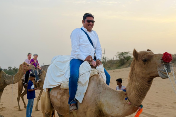 Tourists enjoying a camel ride through the golden sand dunes of Osian near Jodhpur